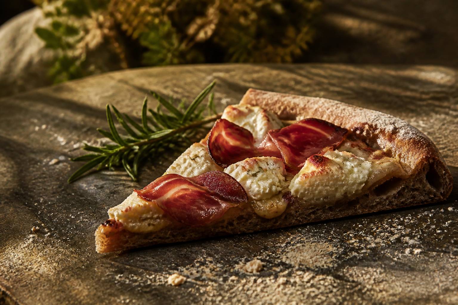 Part de pizza au brocciu et à la coppa sur une surface en pierre
