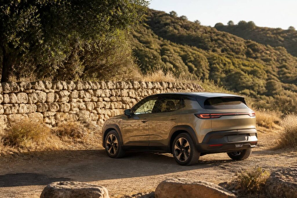 SUV électrique garé devant un mur en pierre sous un soleil chaud