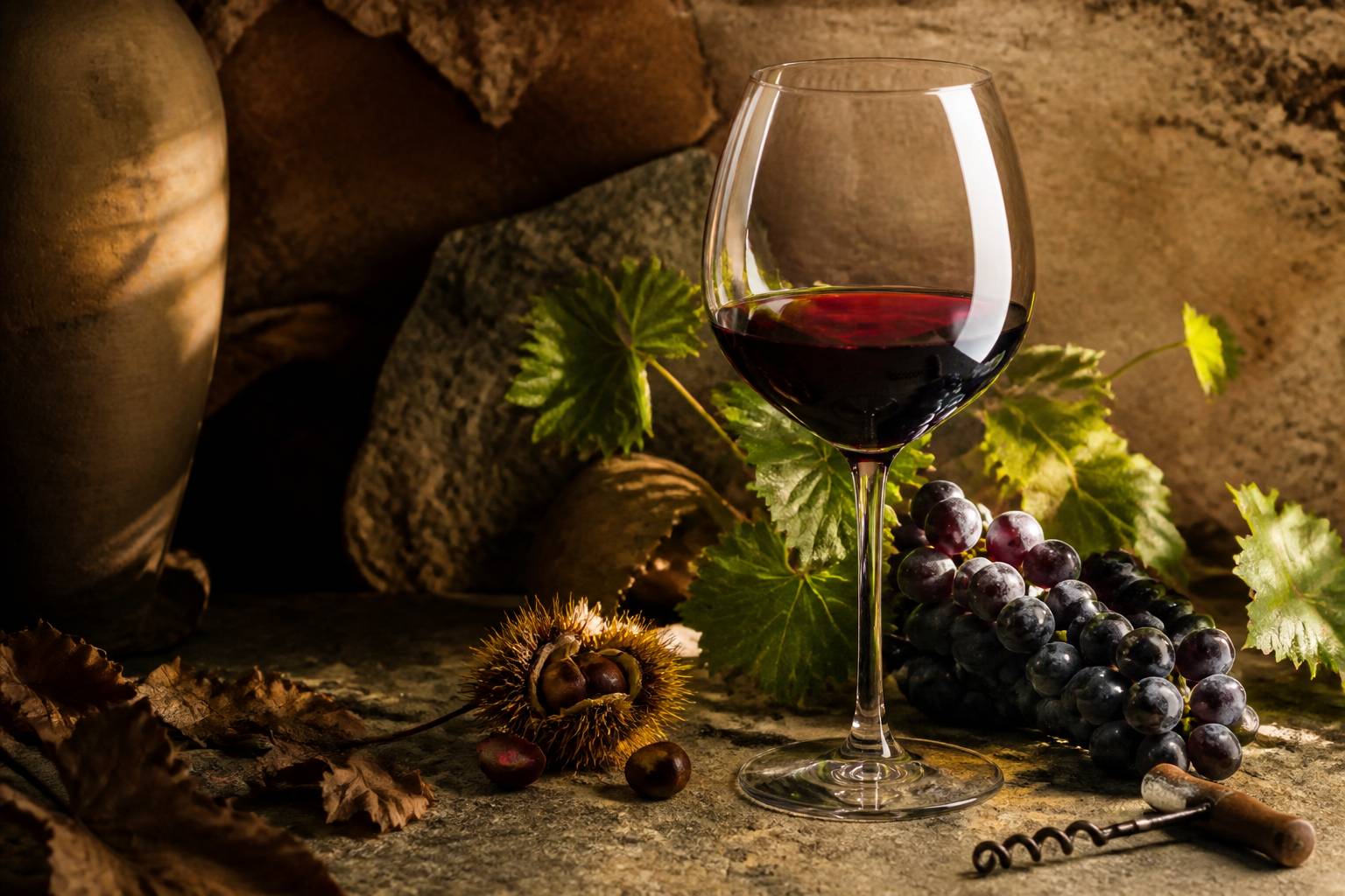 Verre de vin rouge avec des raisins noirs sur une table